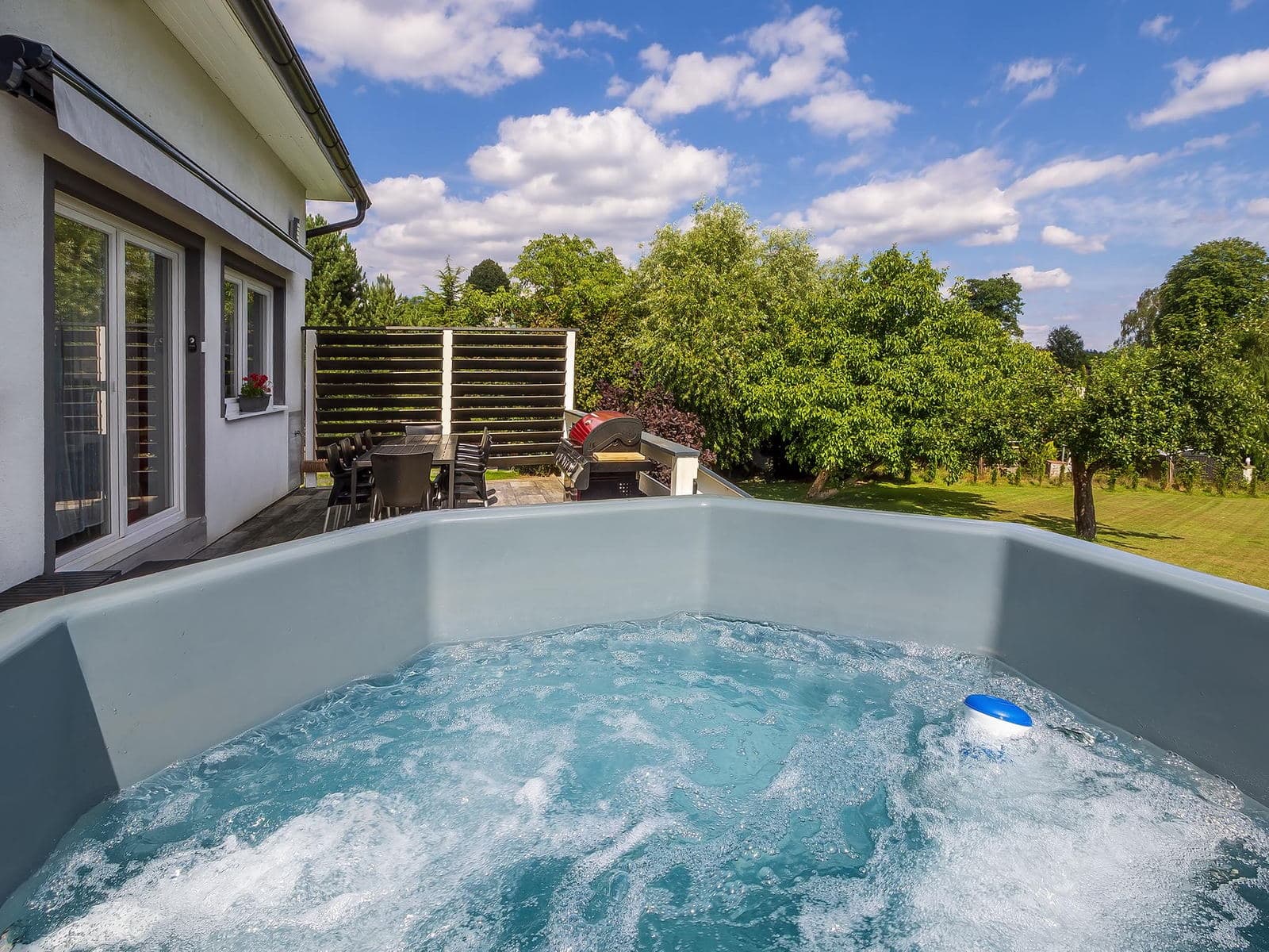 Bubbling hot tub overlooking the terrace and the orchard