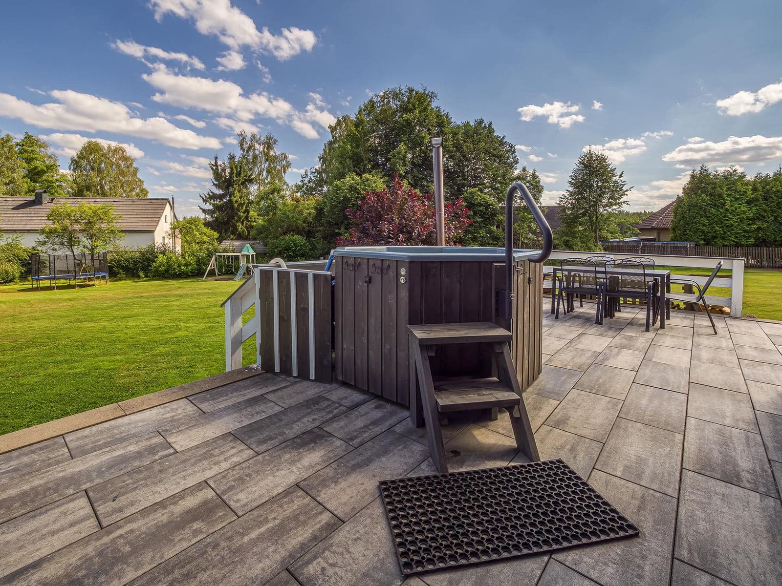 Terrace with seating and a heated hot tub
